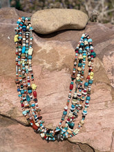 Load image into Gallery viewer, There is Turquoise, Coral, Hubble Glass Beads, Lapiz, Sterling Silver beads, and Stones all strung together on a braided 34" rope.
