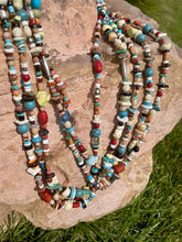 Load image into Gallery viewer, There is Turquoise, Coral, Hubble Glass Beads, Lapiz, Sterling Silver beads, and Stones all strung together on a braided 34" rope.
